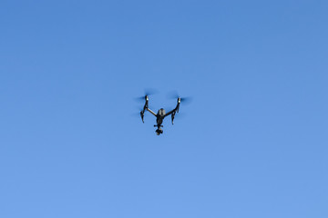 Drone with video camera against the sky.