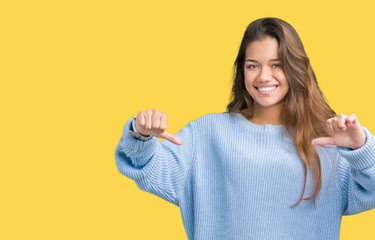 Young beautiful brunette woman wearing blue winter sweater over isolated background looking...