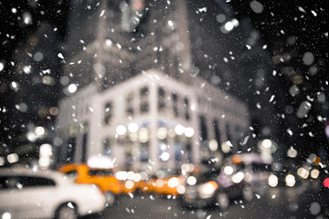 Defocused blur New York City midtown Manhattan street scene with yellow taxi cab and snowflakes...