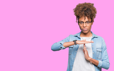Beautiful young african american woman wearing glasses over isolated background Doing time out...