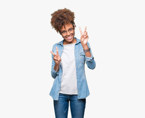 Beautiful young african american woman wearing glasses over isolated background smiling looking to the camera showing fingers doing victory sign. Number two.