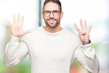 Young handsome man wearing glasses over isolated background showing and pointing up with fingers...