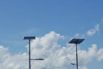 Naklejka na ściany i meble Close up view of LED street light with solar cell on clear blue sky background with clouds.