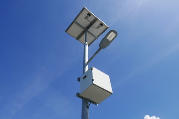 Close up view of LED street light with solar cell on clear blue sky background with clouds.