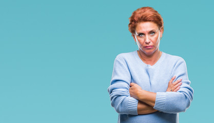 Atrractive senior caucasian redhead woman over isolated background skeptic and nervous, disapproving expression on face with crossed arms. Negative person.