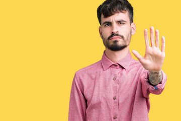 Young handsome man wearing pink shirt over isolated background doing stop sing with palm of the...