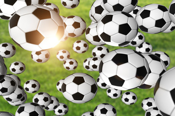 Soccer balls flying on green blurry grass field background. Selective focus used.