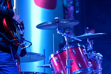 Close-up of young musician is playing guitar in a live music performance in a stage.