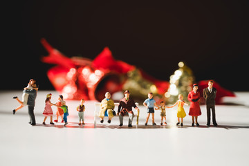 Miniature family people standing on Christmas decoration background using as family and holiday celebration concept
