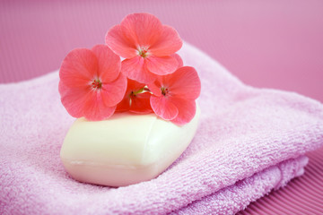Fototapeta na wymiar Fragrant flower soap on a pink towel.