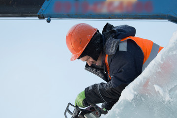 Portrait of a fitter in an orange vest with a chainsaw in his hands