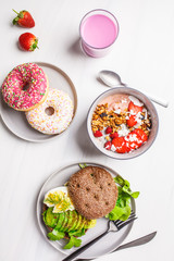 Beautiful breakfast: smoothie bowl, avocado toast and dessert on a white marble background, top view. Valentine's Day concept.