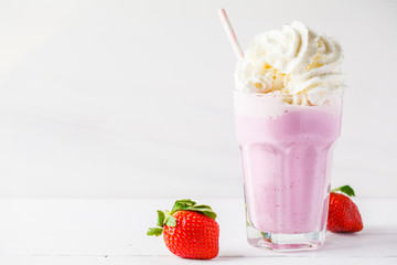 Strawberry milkshake with whipped cream on white background, copy space for text. Valentine's day...