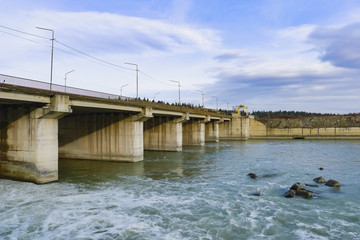 Old dam over the river. Post Soviet construction. Bridge and dam on the river