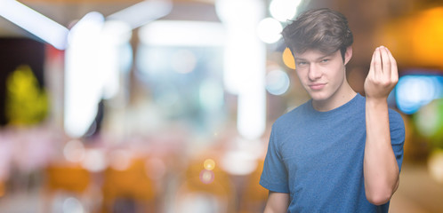 Young handsome man wearing blue t-shirt over isolated background Doing Italian gesture with hand...