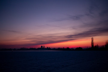 Colorful sunset. On the horizon you can see the silhouette of buildings