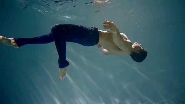 Underwater shot of a man underwater in pants float up youth activities teen adventure active lifestyle Hobby