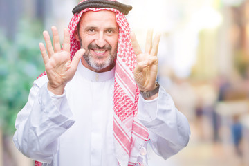 Senior arab man wearing keffiyeh over isolated background showing and pointing up with fingers...