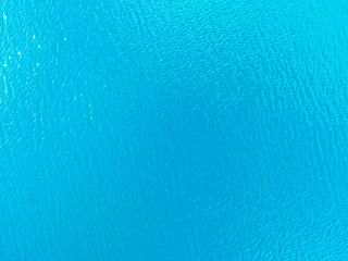 Aerial view of a Crystal clear sea water texture. View from above Natural blue background. Turquoise ripple water reflection in tropical beach. Blue ocean wave. Summer sea. Drone. Top view