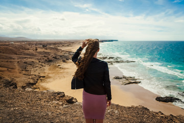 El Cotillo, Fuerteventura, Canary Island, Spain. A young girl is on the top of the cliff and looks...