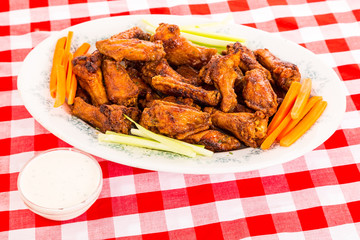 Platter of spicy chicken wings with dipping strips and ranch dressing