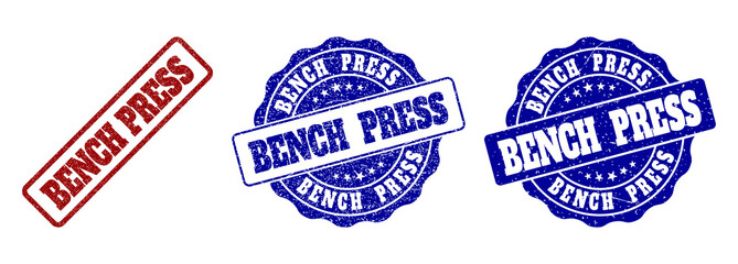 Obraz premium BENCH PRESS scratched stamp seals in red and blue colors. Vector BENCH PRESS imprints with scratced effect. Graphic elements are rounded rectangles, rosettes, circles and text tags.