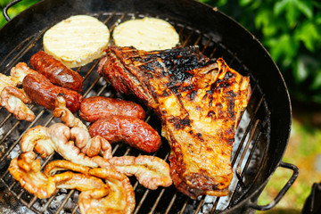 Close-up meat, sausages and cheese cooking on a barbecue grill Argentina