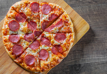 Pepperoni Pizza with Mozzarella cheese, salami, Tomatoes, pepper. Italian pizza on wooden table background