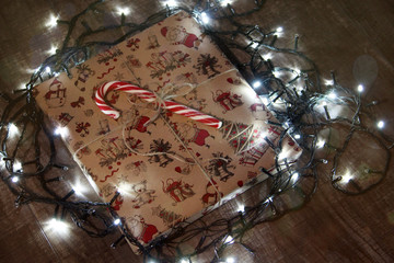 Christmas gifts under the tree with lights. Box of Christmas gifts. Festive mood.