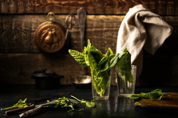 Fresh leaves of sorrel in a glass cup on a table in the kitchen. wooden background. Copy space