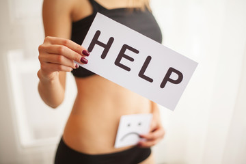 Woman Health Problem. Closeup Of Female With Fit Slim Body In Panties Holding White Card With Word...