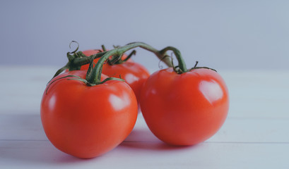 Red, juicy tomatoes on wooden background, concept: fresh vegetables, healthy food.
