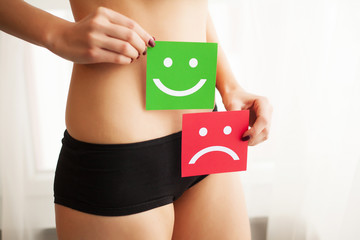 Woman Health Problem. Closeup Of Female With Fit Slim Body In Panties Holding Two Card With Sad...