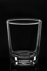 Empty whiskey glass cup on a black background
