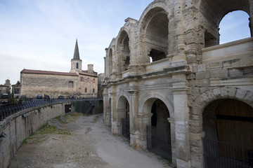 Arles, France - April 29 / 2018 : Arles Amphitheatre at the right side and the church at front