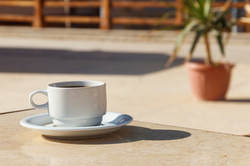 Cup of coffee on a table in cozy outdoor cafe