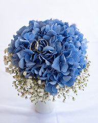 Eheringe einer Hochzeit mit bunten Blumen