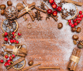 Christmas decoration with spices on a dark wooden background, covered by snow.