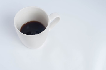 white mug of coffee on a white background with a spoon
