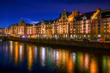 The Warehouse District (Speicherstadt) in Hamburg, Germany, at night. The panoramic view is across the inner harbor (Binnenhafen) with the bridge "Brooksbrücke".