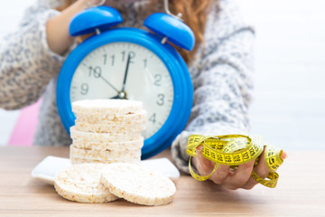 diet and slimming concept, corn cakes with tape measure and girl