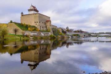 Fototapeta na wymiar Sightseeing of Estonia. Beautiful autumn view of Narva Castle with tall Herman's tower, Narva, Estonia