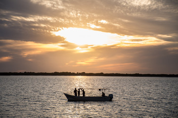 personas viendo el atardecer en una lancha 