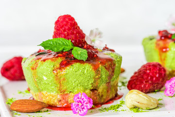 cheesecake made of matcha green tea powder with raspberries, mint, nuts and flowers. healthy delicious food