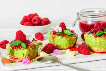 green matcha vegan raw cheesecakes with raspberries, mint, nuts and jam. healthy delicious food