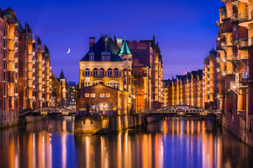 The Warehouse District (Speicherstadt) in Hamburg, Germany, at night. View of Wandrahmsfleet. The...