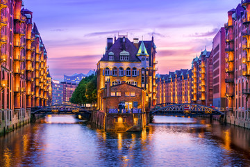 The Warehouse District (Speicherstadt) in Hamburg, Germany, at dusk. View of Wandrahmsfleet. The...