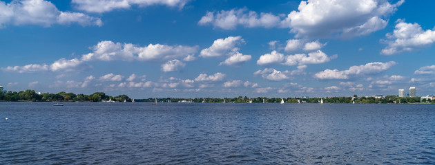 The lake Alster in Hamburg, Germany, with sailboats in the afternoon. Panoramic view. The Außenalster (Outer Alster) serves as important recreational area in the heart of the city.