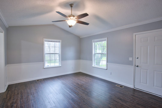 Gray living room interior with vaulted ceilings and chair rail.