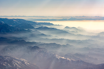 Fototapeta na wymiar Aerial view of the fog laden Tian Shan mountain range in China near Ürümqi